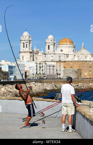 Due uomini la pesca non lontano da Catedral de la Santa Cruz sobre las Aguas de Cádiz / Cádiz cattedrale, Cadice, Andalusia, Spagna Foto Stock