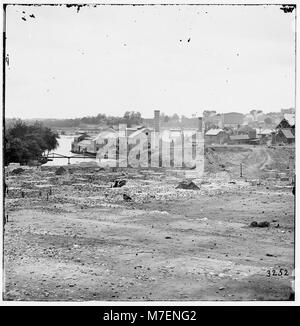 Una fotografia storica di Tredegar Iron Works a Richmond, Virginia, con una passerella che porta a Neilson's Island. L'immagine evidenzia il paesaggio industriale della zona. Foto Stock