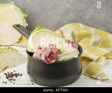 La cottura tradizionale norvegese piatto di brasato di cavolo con agnello (Forikol). Gli ingredienti sul tavolo. Verdure, carne , Pepe nero e spezie Foto Stock