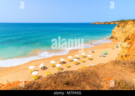 Ombrelloni e lettini sulla spiaggia di sabbia Praia da Rocha in città di Portimao, Portogallo Foto Stock