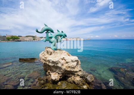 Statua di delfini in spiaggia al di fuori della città vecchia di Rodi, Grecia Foto Stock