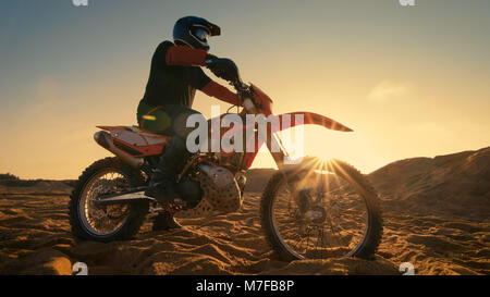 Bassa Angolazione del Motocross professionale conducente seduto sul suo FMX moto completa torsione impugnatura a farfalla e pronto a cavalcare estremamente veloce Foto Stock