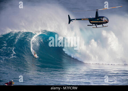 Un elicottero filmare un tow-in surfer a Peahi (ganasce) off Maui. Hawaii. Foto Stock