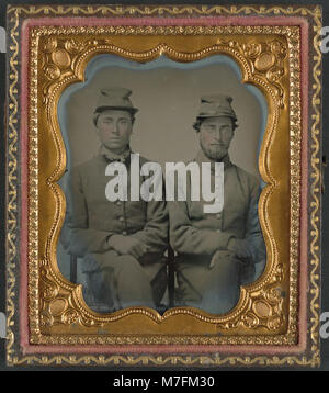 Una fotografia storica che mostra due soldati confederati non identificati che indossano uniformi e cappelli contrassegnati con "W.G.", catturando un momento della guerra di secessione americana, in particolare l'esercito confederato. Foto Stock