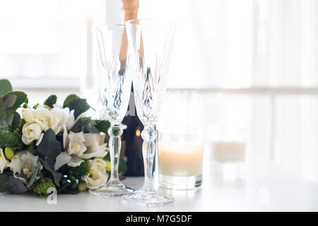 Bellissime decorazioni per matrimoni con champagne e fiori bianchi e un decor elegante con cristallo bicchieri di vino sul tavolo Foto Stock