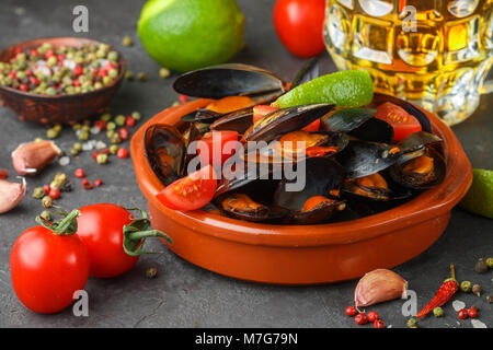 Le cozze in conchiglie con pomodoro e salsa piccante del peperoncino e aglio. Gustosi snack alla birra. Piatti mediterranei. Messa a fuoco selettiva Foto Stock