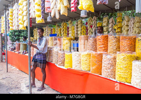 Uomo indiano e il suo snack stallo a Shivratri festival Foto Stock