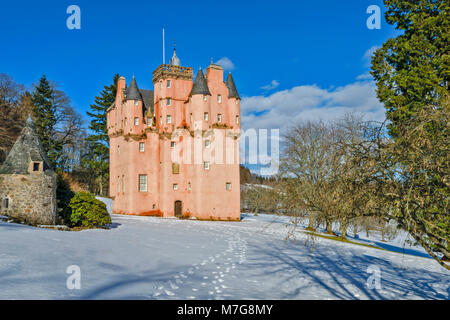 Castello di Craigievar ABERDEENSHIRE in Scozia un cielo blu e impronte conducono verso la torre rosa circondato da abeti e neve invernale Foto Stock