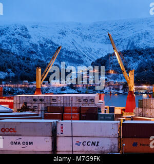 I contenitori di spedizione in porto Alesund, Norvegia con sullo sfondo di montagne innevate in inverno Foto Stock