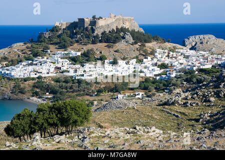 Vista complessiva dell'Acropoli e le rovine del castello dei Cavalieri di San Giovanni a Lindos, tradizionale architettura greca sotto la collina, Rodi, greco Foto Stock