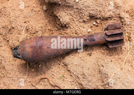 Vecchio mortaio inesplose shell granata sulla sabbia Foto Stock