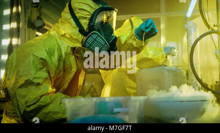 In metropolitana farmaco due laboratori chimici clandestino indossando maschere protettive e tute cotta di prova della droga di purezza e di potenza. Foto Stock