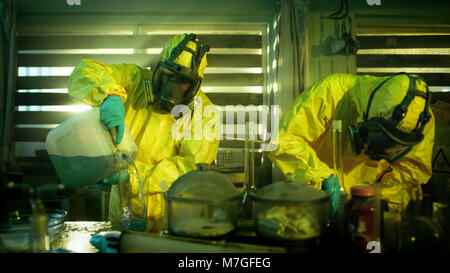 Nel farmaco sotterranea clandestina di laboratorio chimici indossare maschere protettive e tute Mix Prodotti Chimici per sintetizzare il nuovo lotto di farmaci. Foto Stock