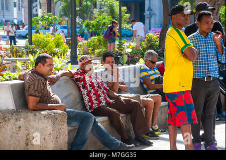 Un gruppo di uomini cubana il resto al Parque Central a l'Avana, Cuba Foto Stock