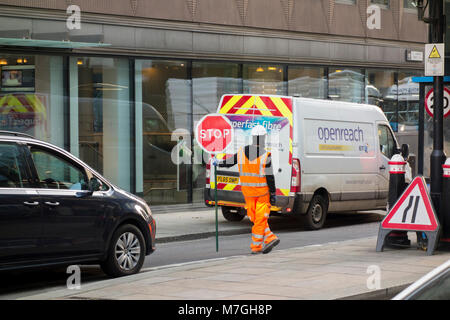 Workman in alta vis tenendo premuto stop nella parte anteriore del BT Openreach superfast fibre van Foto Stock