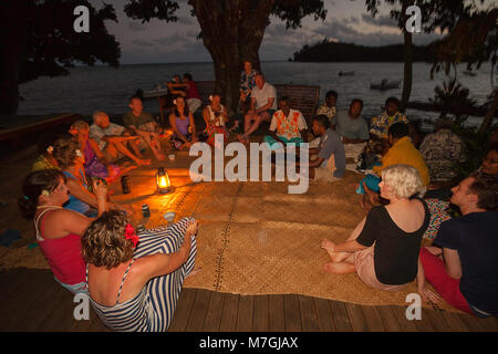 Un gruppo di ospiti seduti in cerchio su stuoie tessute a Matava Resort sull'isola di Kadavu, godendo di Kava, Fiji. Foto Stock