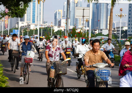 Persone il pendolarismo nelle prime ore del mattino su biciclette e scooter in una corsia separata nella città di Nanning, Guangxi, a sud ovest della Cina. Foto Stock