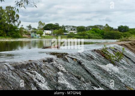 Il weir vicino Riverview Tavern di Douglas con acqua che scorre sopra la parte superiore, Townsville Queensland Australia Foto Stock