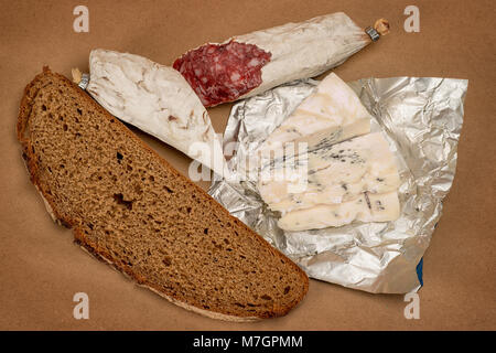 La prima colazione a tema vita ancora. Pane, formaggio Roquefort e salsiccia affumicata su marrone craft sfondo della carta Foto Stock