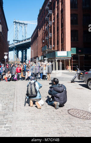 Un gruppo di fotografi asiatici fotografato di fronte a un classico Brooklyn vista del Manhattan Bridge in Dumbo Foto Stock