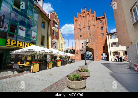 OLSZTYN, Polonia - Giugno 08, 2017: passerella di ciottoli si è conclusa con lo stile gotico alto cancello nella Città Vecchia di Olsztyn Foto Stock