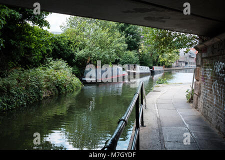 Sotto un ponte sul Grand Union Canal a est di Camden Town con una vista delle barche strette, London, Regno Unito Foto Stock