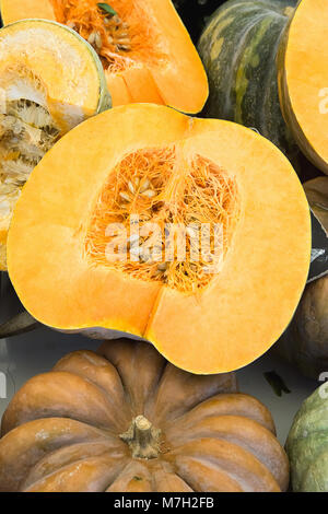 Grande bellissimo colorato arancione scuro e verde zucche intero e dimezzato. Dent Texture semi. Mercato degli Agricoltori. Ringraziamento raccolto in autunno. Prodotti biologici Foto Stock