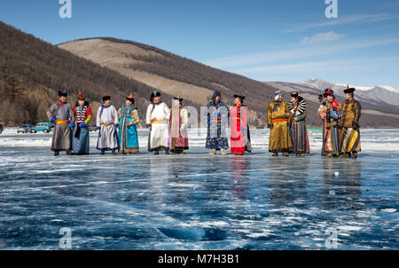 Hatgal, Mongolia, 4 Marzo 2018: popolo mongolo vestito in abiti tradizionali su un lago ghiacciato Khuvsgul Foto Stock