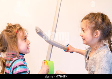 Due ragazze con le spade giocattolo giocare cavalieri. Deyochki sostengono e si adirano. conflitto. Foto Stock