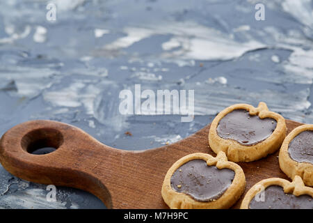 Vista superiore ritratto di close-up di gustosi piatti a forma di mela di cookie sul bordo di taglio al di sopra della luce di sfondo astratto, profondità di campo, il fuoco selettivo. Foto Stock