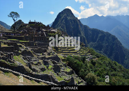 La cima della montagna di Huayna Picchu sorge la protezione sopra la vecchia città Inca di Machu Picchu in le montagne delle Ande del Perù. Foto Stock