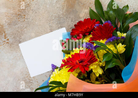 Una storia di nozze o sullo sfondo della mamma. Bouquet di gerbera con crisantemi e presente su una pietra blu di sfondo o calcestruzzo. Foto Stock