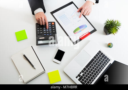 Vista ravvicinata del contabile o ispettore finanziario mani rendendo relazione, il calcolo o il controllo di equilibrio. Foto Stock