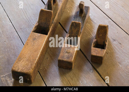 Vecchio di legno piani a mano sul pavimento in legno nella camera a vuoto all'interno di un vecchio 1800s cottage in stile casa. Foto Stock