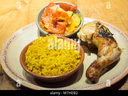 Peri-peri quarto di pollo con i lati di riso speziato e peri-peri verdura da Nando's, un casual dining catena che proviene dal Sud Africa. Foto Stock