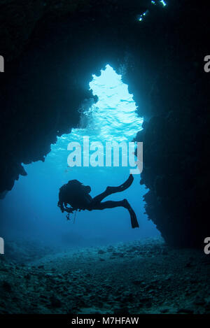 Un subacqueo in uscita una nuotata attraverso la caverna, Kadavu Island, Fiji. Foto Stock