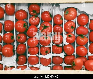 Pomodori vista superiore pomodori freschi maturi sono giacenti in una scatola di legno sul mercato counter Foto Stock