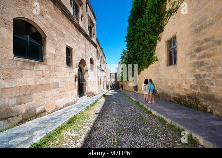 Irriconoscibile turisti tenendo selfie sulla strada Ippoton noto come Cavalieri Street - strada stretta della vecchia città medievale di Rodi rivestita con pensioni di diff Foto Stock