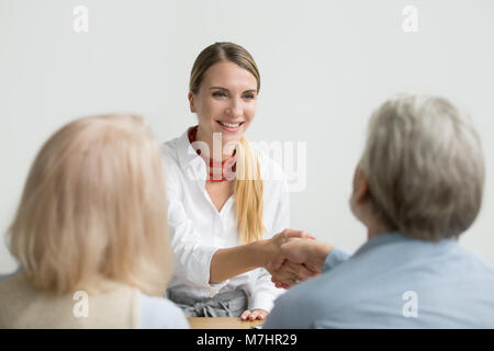 Sorridente imprenditrice agitando la mano di senior hr presso il colloquio di lavoro Foto Stock