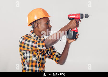 African American lavoratore utilizza cacciavite elettrico Foto Stock