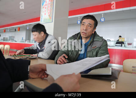 (180311) -- Pechino, 11 marzo 2018 (Xinhua) -- Mi Zhongyi (R), neo-eletto deputato al XIII Congresso nazionale del popolo (ANP), discute con il suo collega presso la mensa degli apparati di trasmissione società del Nord Heavy Industries Group Co., Ltd. in Shenyang, a nord-est della Cina di Provincia di Liaoning, Feb 23, 2018. Mi Zhongyi è un lavoratore presso le apparecchiature di trasmissione società del Nord Heavy Industries Group Co., Ltd. in Shenyang. Si dedica al lavoro quando lui per primo ha aderito alla società nel 1983. Anni di pratica e di studio si sono rivolti a lui in un tecnico senior. Una dozzina di suo Foto Stock