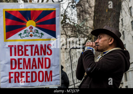 Londra, Regno Unito. Il 10 marzo 2018. Un uomo porta alcuni canti al rally prima dell'annuale Tibet libertà marzo a Londra per commemorare il 59e anniversario della Rivolta Nazionale Tibetana. Diverse centinaia di persone, compresi molti tibetani e i sostenitori di raccogliere a Downing St prima di marciare a una protesta presso l'ambasciata cinese. Prima del mese di marzo a sinistra vi era un minuto di silenzio per coloro che sono morti, compresi da auto-immolazione, e una lunga preghiera tibetano, seguita dal canto del popolo tibetano inno nazionale. esLiv Credito: ZUMA Press, Inc./Alamy Live News Foto Stock