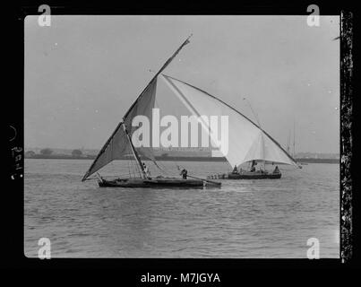 Una scena raffigurante le tradizionali "faluka" navigando sul Nilo vicino al Cairo, in Egitto. Queste barche sono note per le loro vele triangolari e il significato storico nella regione. Foto Stock