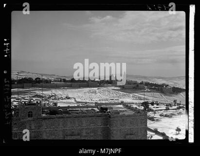 Questa fotografia mostra una scena innevata di Gerusalemme, presa dalla torre YMCA l'8 febbraio 1932. L'immagine cattura l'ambiente unico della città durante un raro evento di neve. Foto Stock