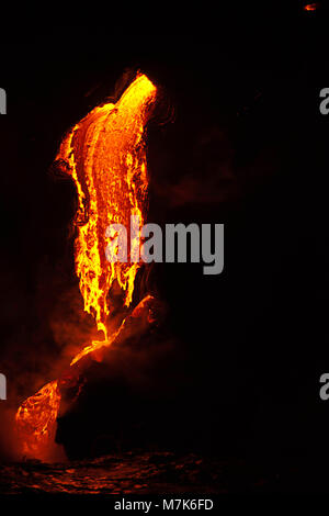 In pre-alba tenebre la lava pahoehoe che fluisce dal Kilauea raggiunge l'oceano Pacifico vicino Kalapana, Big Island delle Hawaii. Foto Stock