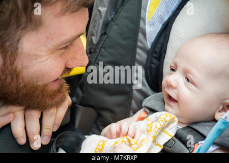 Uomo sorridente in questo figlio bambino. 3 mesi di età. Foto Stock