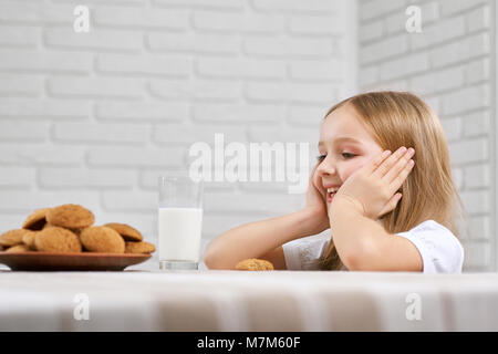 Close-up di una bambina cerca su cookie. Foto Stock