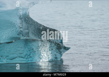 Blu chiaro iceberg in acqua sulla spiaggia Foto Stock