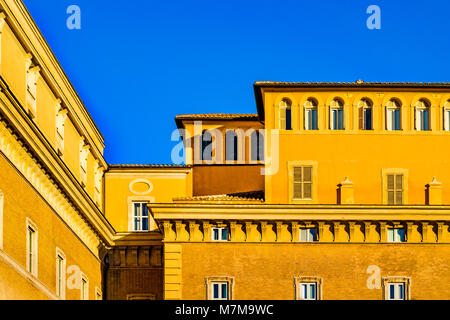 La facciata esterna del tipico palazzo romano stile con colori arancione contro il cielo blu sullo sfondo Foto Stock