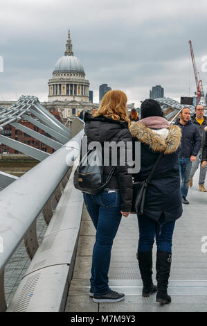 London, Regno Unito - 10 Marzo 2018: la cattedrale di San Paolo e di turisti rendendo selfie usando un bastone selfie al Millennium bridge Foto Stock